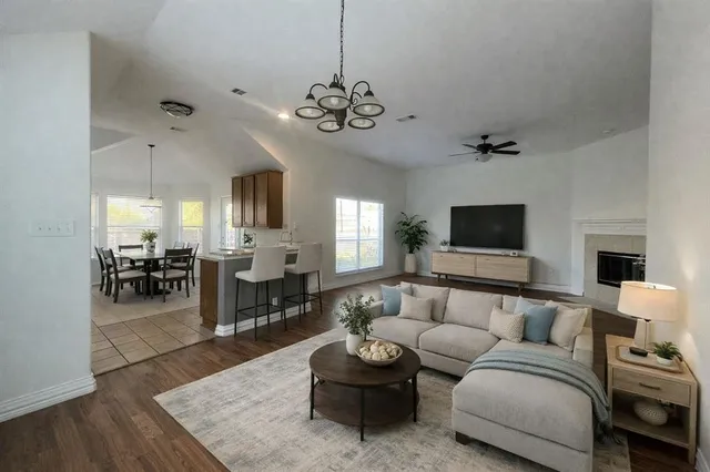 a living room with furniture kitchen view and a flat screen tv