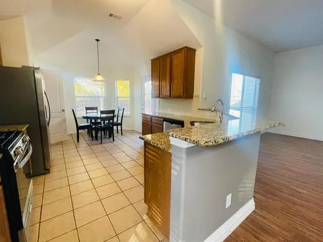 a kitchen with stainless steel appliances granite countertop a refrigerator and a stove top oven
