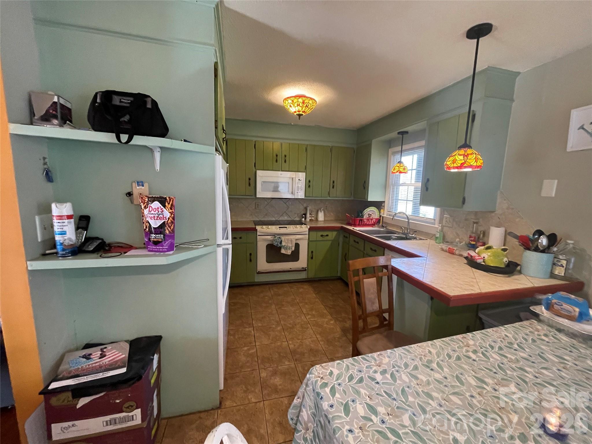 4907 Delmar Griffin Road Monroe, NC 28112 - Photo 6 of 25 a kitchen with a sink a stove and chairs in it