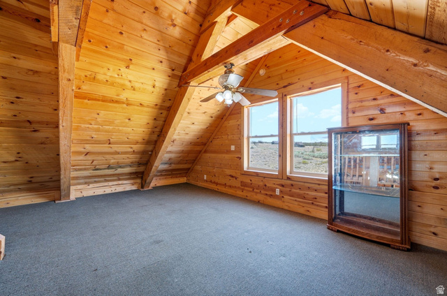 10937 South County Road, Unit 29 Duchesne, UT 84021 - Photo 22 of 41 Vaulted wood-paneled ceilings featuring exposed beams, two large windows, a ceiling fan fixture, and wall-to-wall carpeting