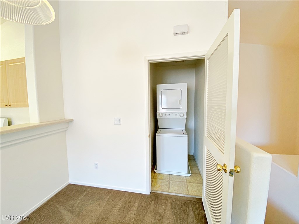9335 Indian Corn Court, Unit 101 Las Vegas, NV 89178 - Photo 8 of 18 Laundry room with stacked washer / drying machine and carpet floors