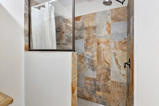 a bathroom with a shower and a mirror