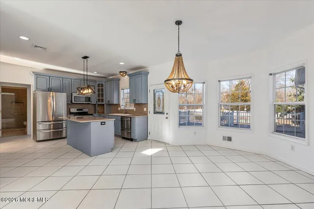 a kitchen with stainless steel appliances a refrigerator sink and microwave