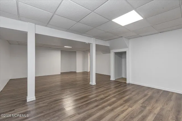 an empty room with wooden floor and natural light