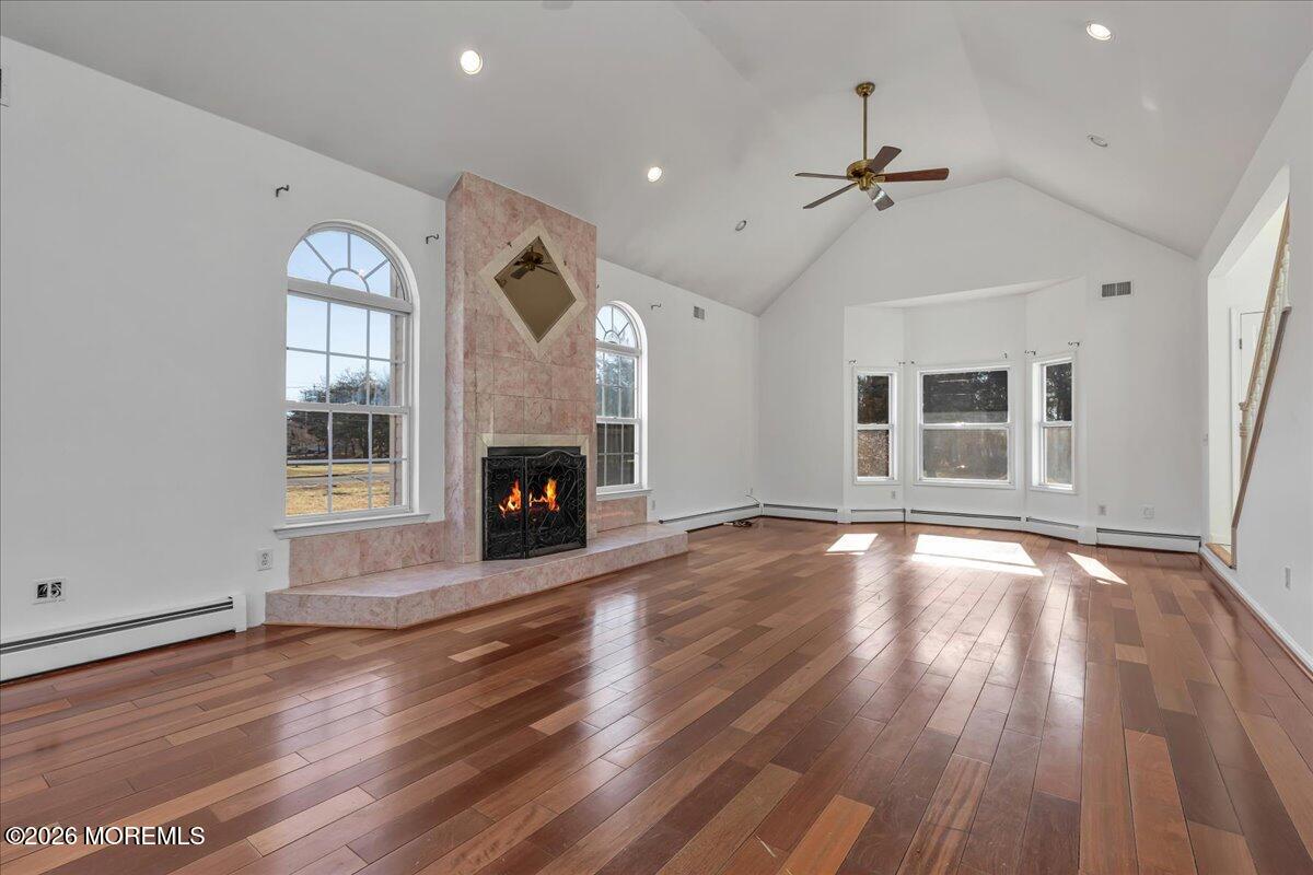 257 Ford Road Howell, NJ 07731 - Photo 8 of 45 an empty room with wooden floor fireplace and windows