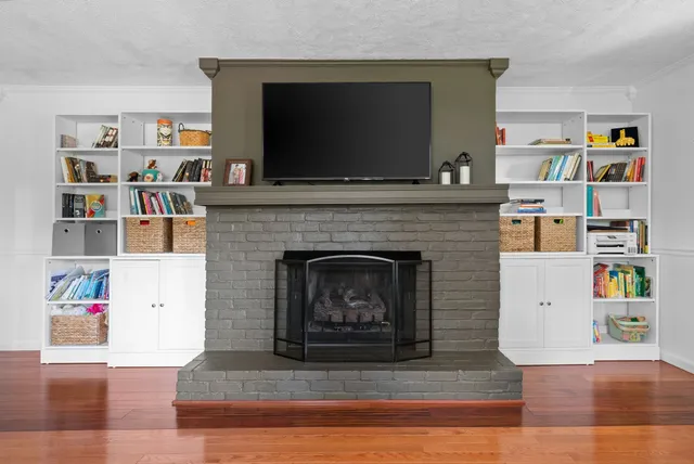 a living room with a bookshelf and a fireplace