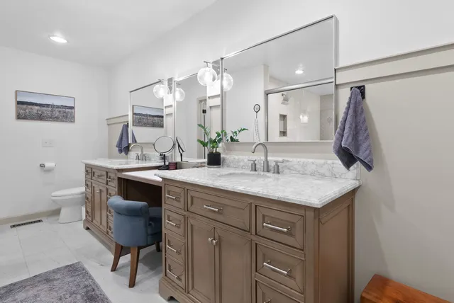 a bathroom with a granite countertop sink a toilet and a mirror