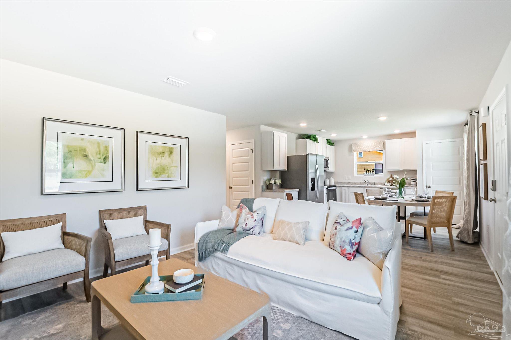 6274 June Bug Drive Milton, FL 32583 - Photo 6 of 17 a living room with furniture a wooden floor and a kitchen view