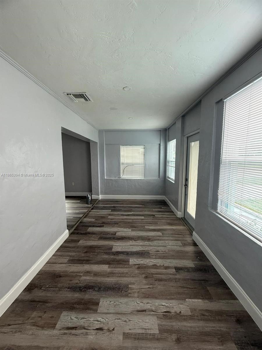 173 West 16th Street, Unit A Riviera Beach, FL 33404 - Photo 15 of 17 a view of an empty room with wooden floor and a window