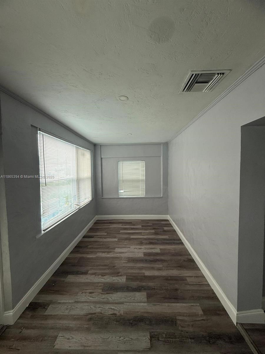 173 West 16th Street, Unit A Riviera Beach, FL 33404 - Photo 7 of 17 a view of an empty room with wooden floor and a window