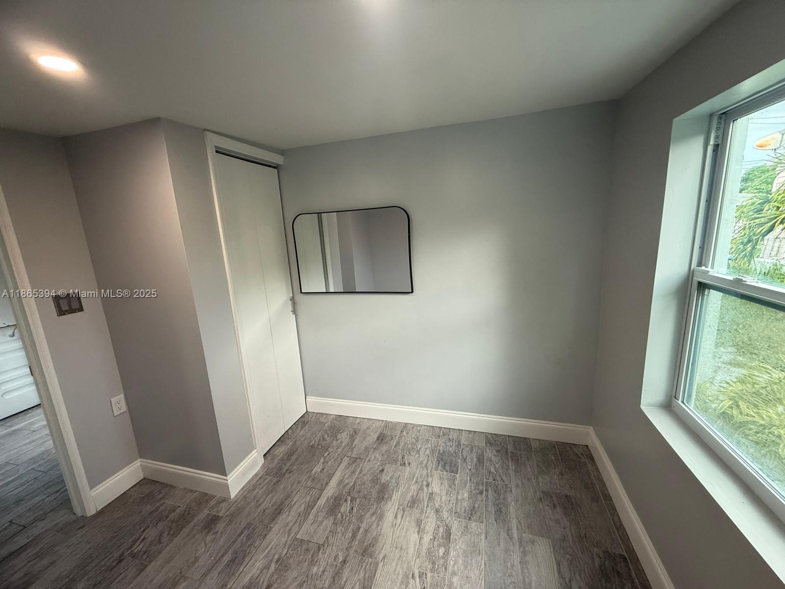 173 West 16th Street, Unit A Riviera Beach, FL 33404 - Photo 9 of 17 an empty room with wooden floor and windows