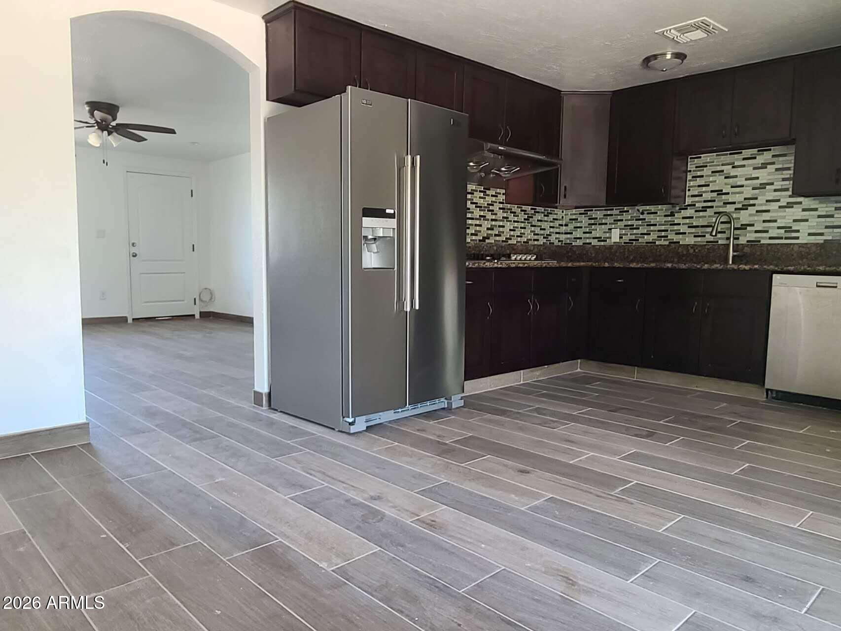 3702 East Thunderbird Road Phoenix, AZ 85032 - Photo 9 of 23 a kitchen with granite countertop a refrigerator and a wooden floor