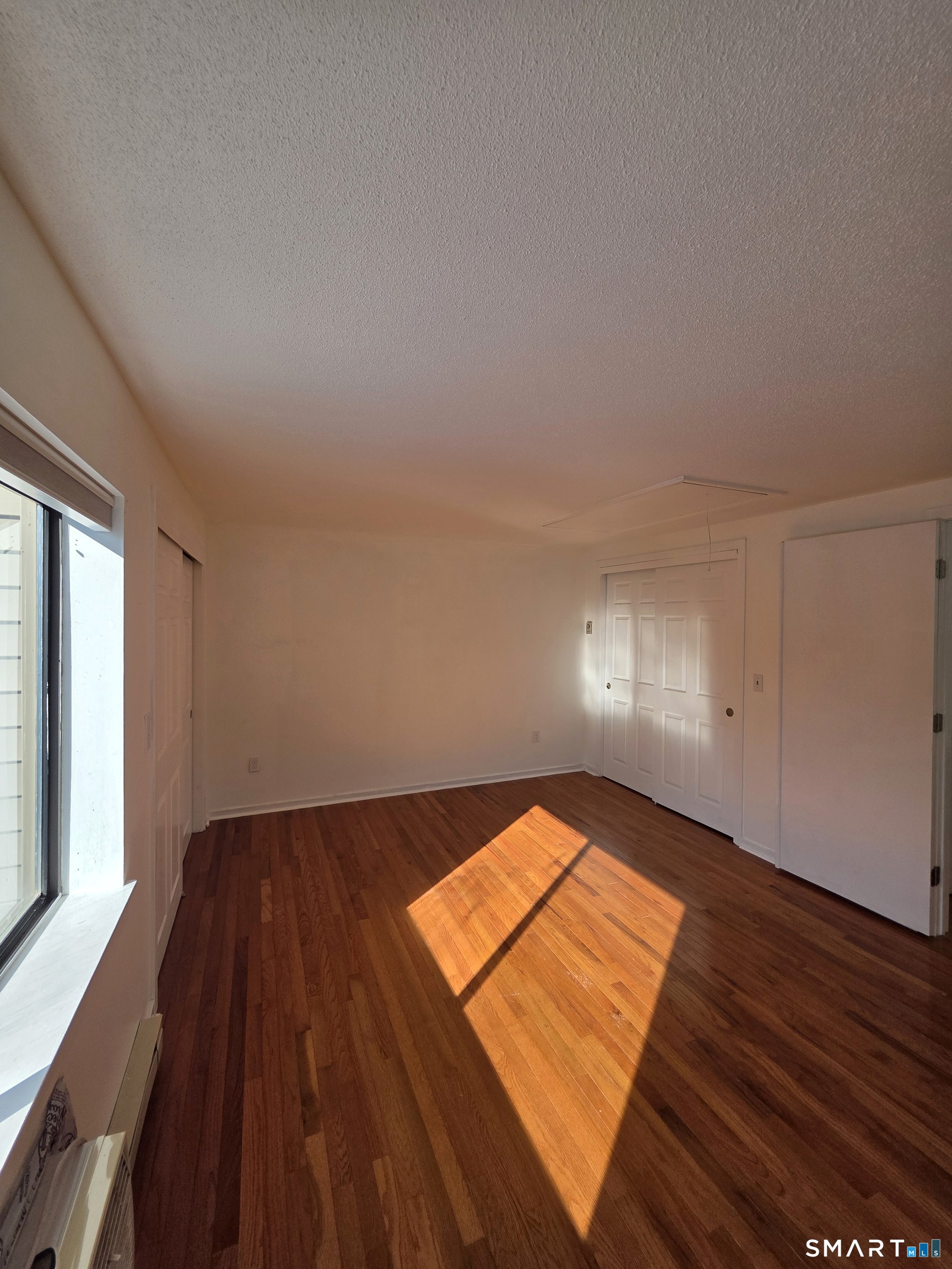 51 Brook Street, Unit 6A Naugatuck, CT 06770 - Photo 24 of 32 an empty room with wooden floor and windows