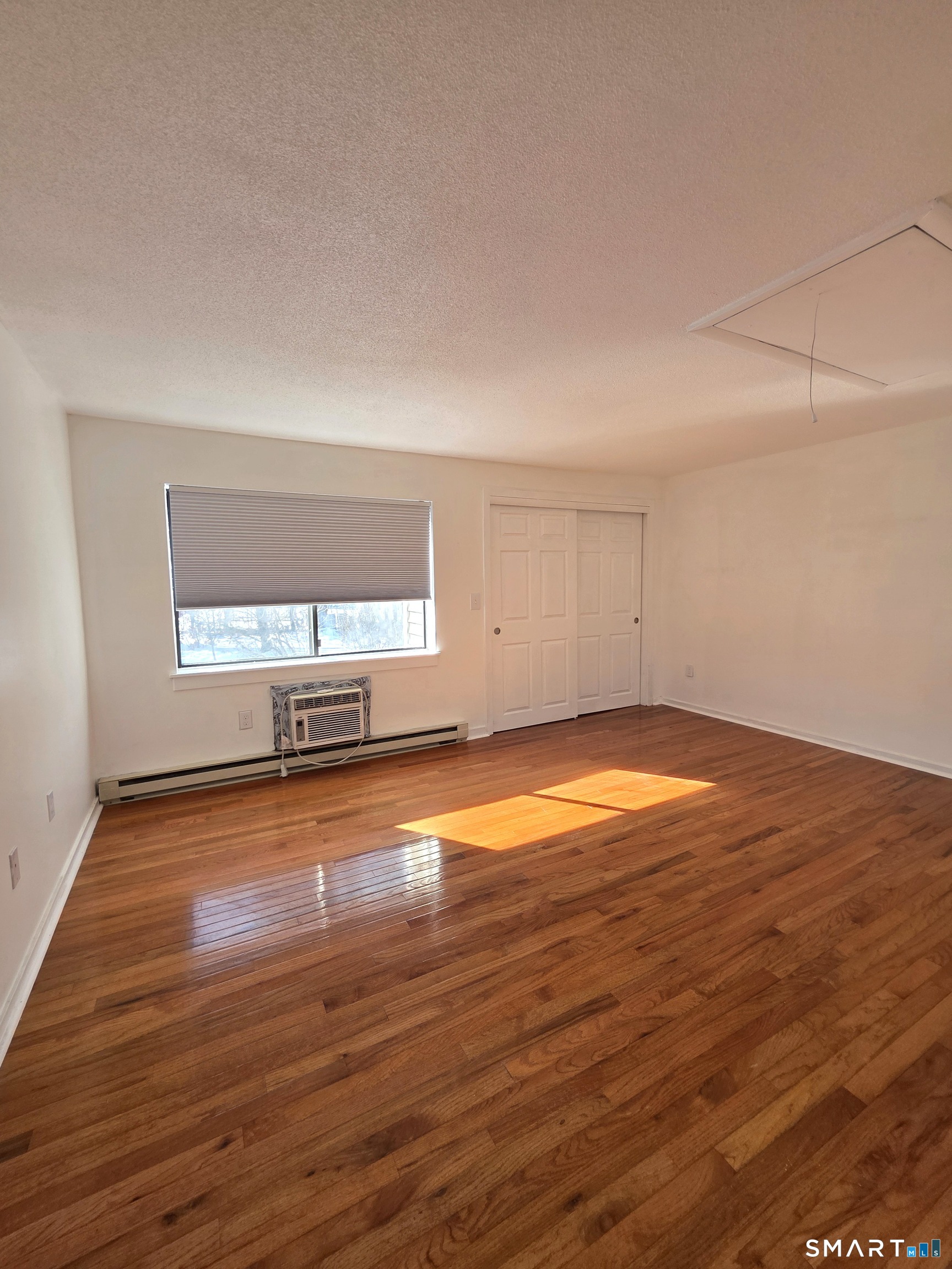 51 Brook Street, Unit 6A Naugatuck, CT 06770 - Photo 26 of 32 an empty room with wooden floor and windows
