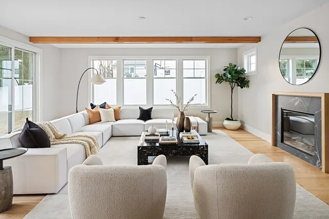 a living room with furniture a large window and a fireplace