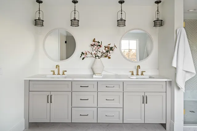 a bathroom with double vanity sinks and a mirror