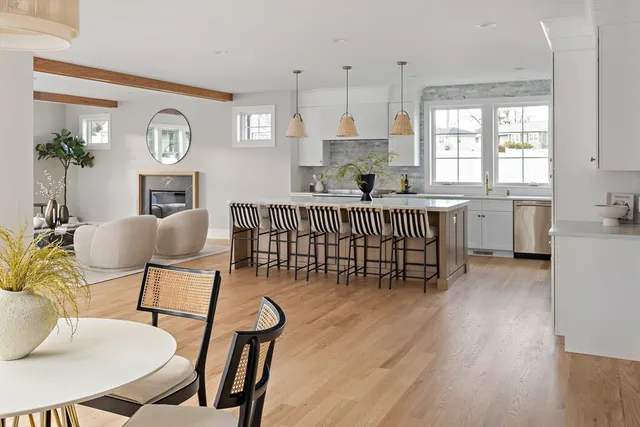 a kitchen with stainless steel appliances a dining table chairs and a refrigerator