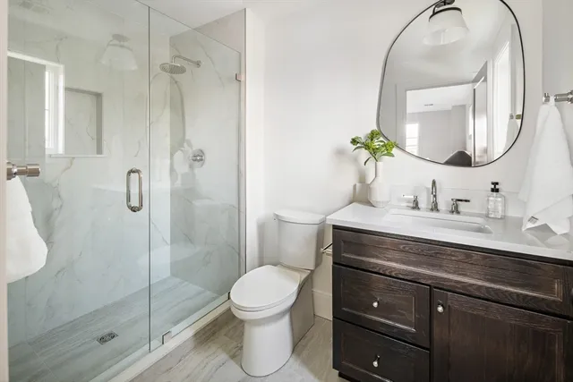 a bathroom with a sink a toilet and shower