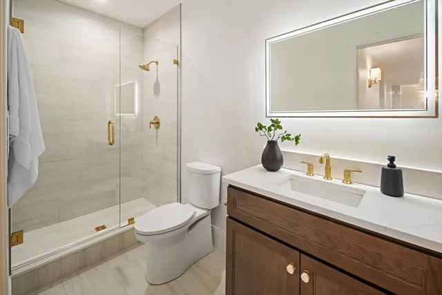 a bathroom with a sink a toilet and shower