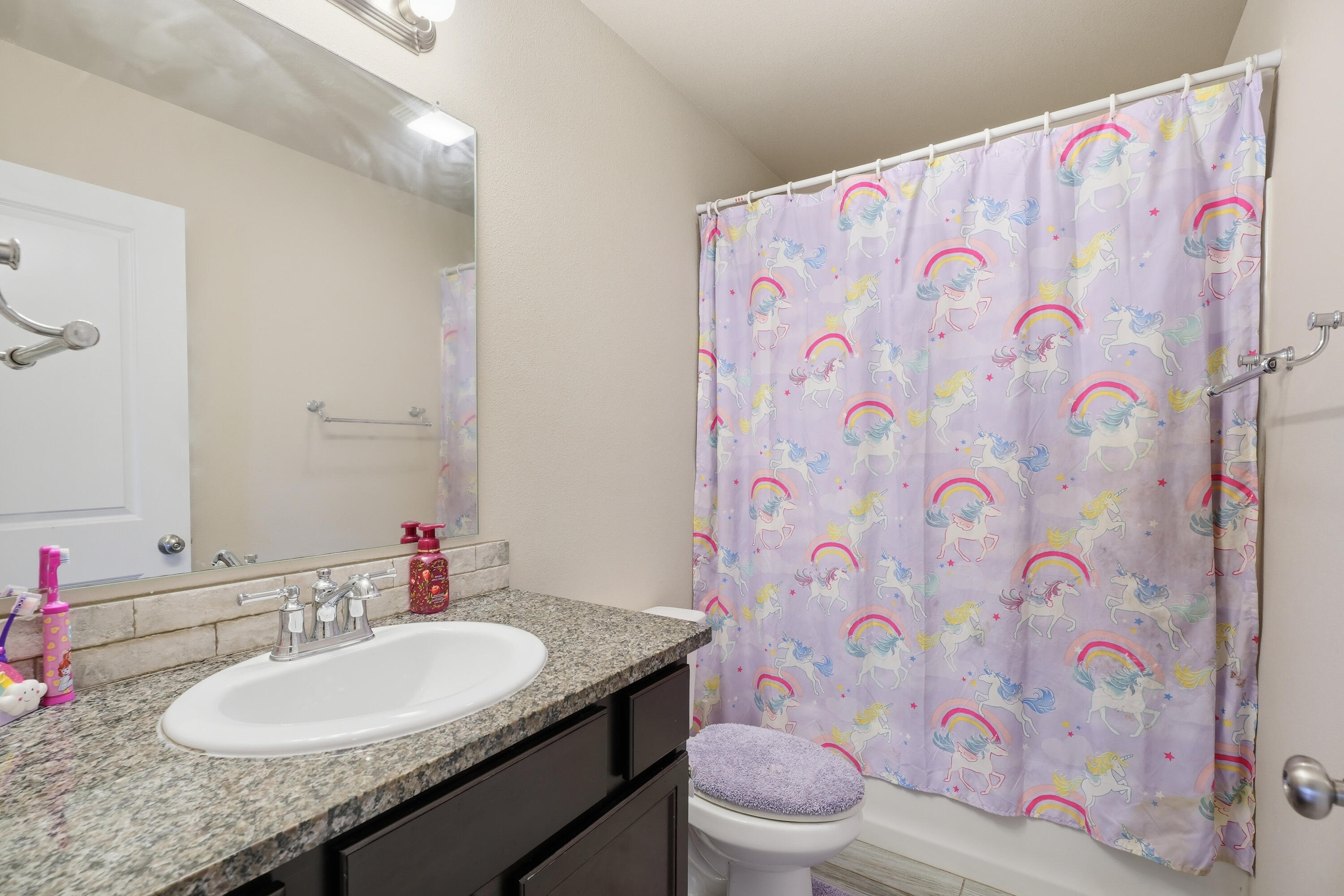 1919 140th Street Lubbock, TX 79423 - Photo 21 of 23 a bathroom with a granite countertop toilet sink and mirror