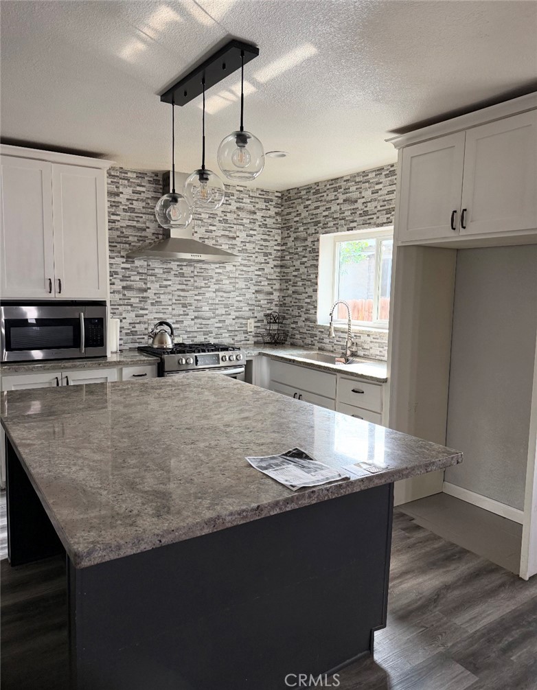 242 East M Street Colton, CA 92324 - Photo 5 of 19 a kitchen with stainless steel appliances granite countertop a sink a stove and a microwave