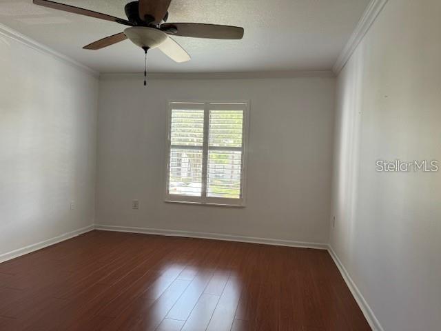 1261 Pine Ridge Circle West, Unit E2 Tarpon Springs, FL 34688 - Photo 13 of 16 an empty room with wooden floor ceiling fan and windows
