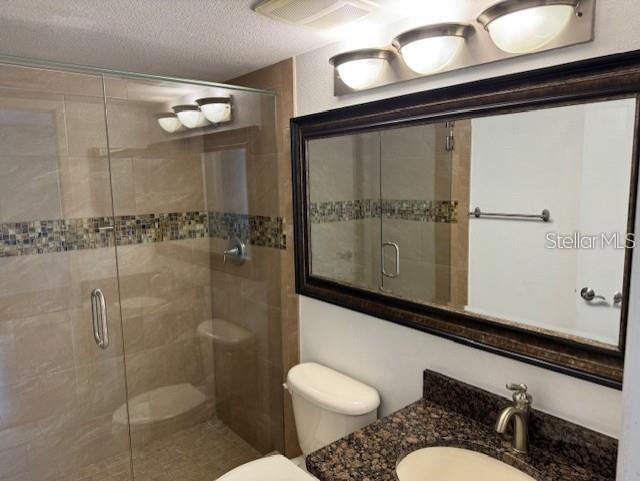 1261 Pine Ridge Circle West, Unit E2 Tarpon Springs, FL 34688 - Photo 15 of 16 a bathroom with a sink toilet a mirror and shower