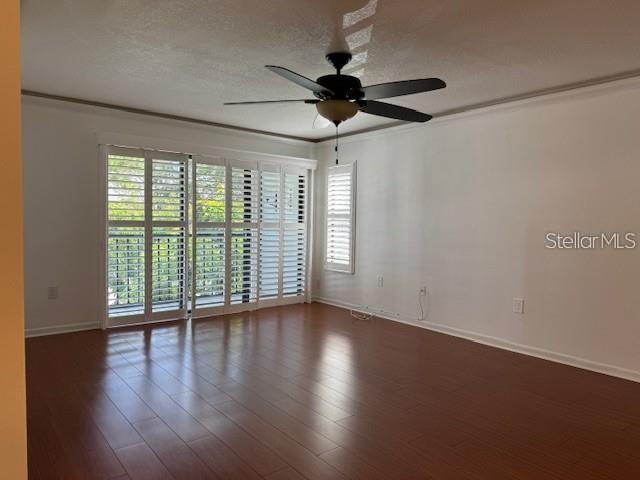 1261 Pine Ridge Circle West, Unit E2 Tarpon Springs, FL 34688 - Photo 2 of 16 a view of an empty room with wooden floor and a window