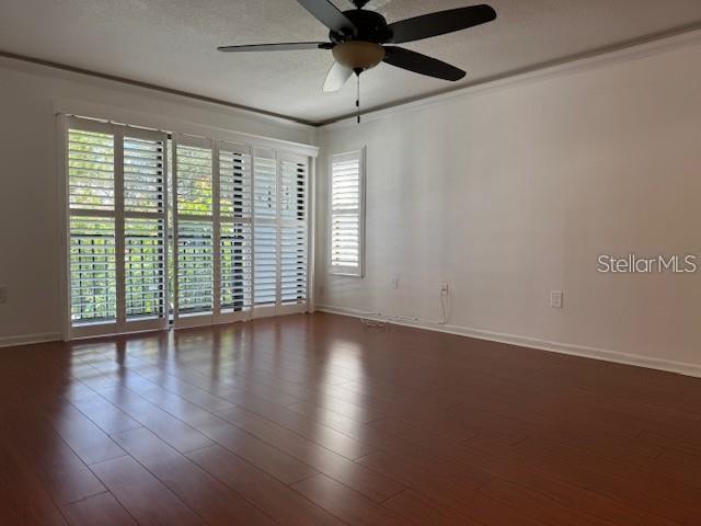 1261 Pine Ridge Circle West, Unit E2 Tarpon Springs, FL 34688 - Photo 3 of 16 a view of an empty room with wooden floor and a window