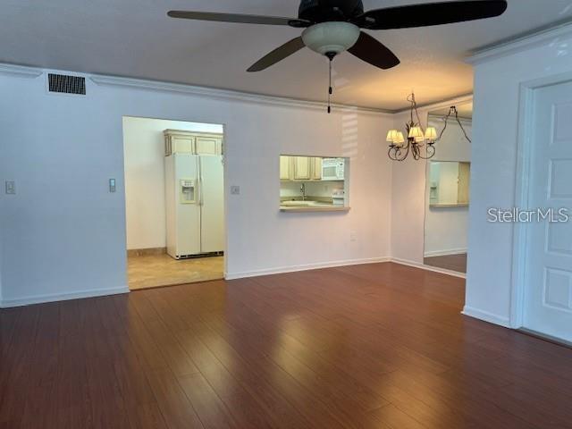 1261 Pine Ridge Circle West, Unit E2 Tarpon Springs, FL 34688 - Photo 5 of 16 a view of an empty room with wooden floor and a ceiling fan