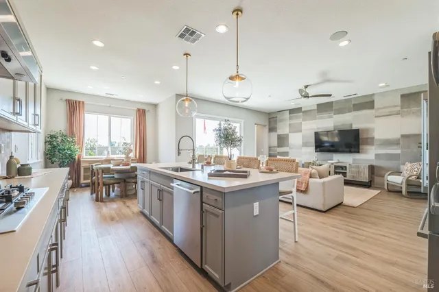 a kitchen with stainless steel appliances a sink a stove a refrigerator and cabinets