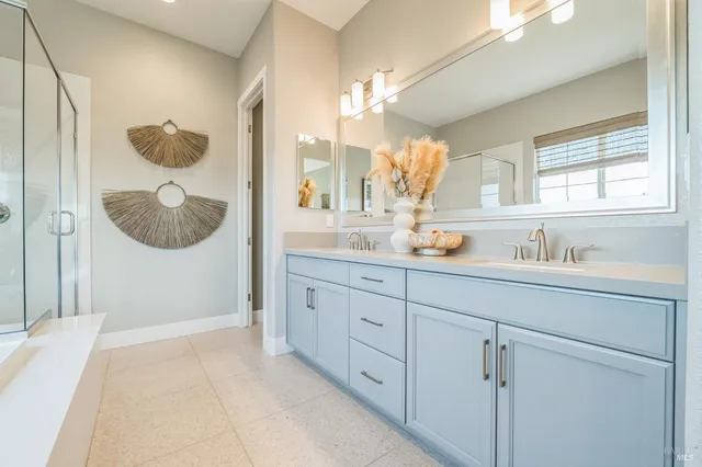 a en suite bathroom with a granite countertop sink and mirror