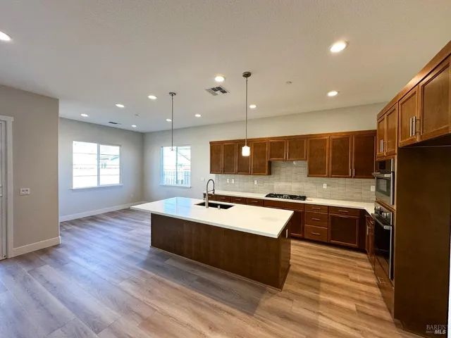 a kitchen with kitchen island a sink a stove and refrigerator