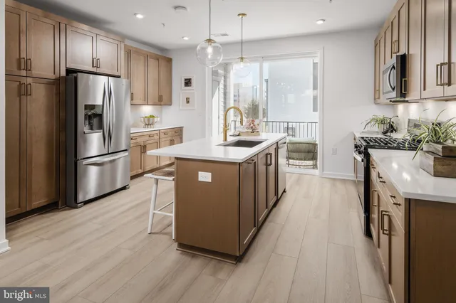 a kitchen with stainless steel appliances granite countertop a refrigerator a stove a sink and a refrigerator