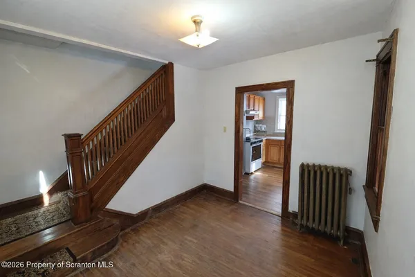 a view of entryway and hall with wooden floor