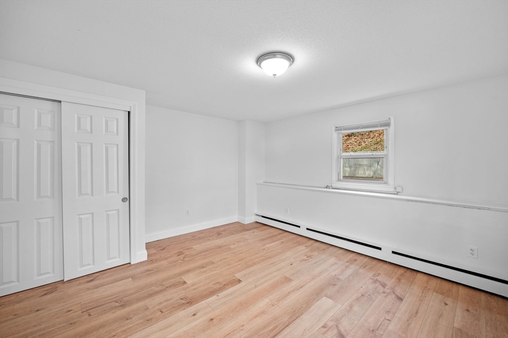 121 Cambridge Road, Unit 2 Woburn, MA 01801 - Photo 14 of 23 an empty room with wooden floor closet and windows