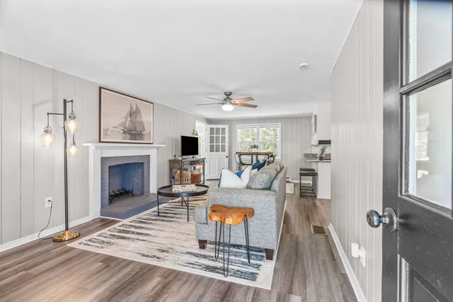 a living room with furniture a fireplace and a large window
