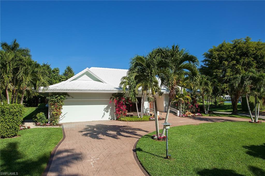 12 Sabre Lane Naples, FL 34102 - Photo 1 of 17 a front view of a house with a garden