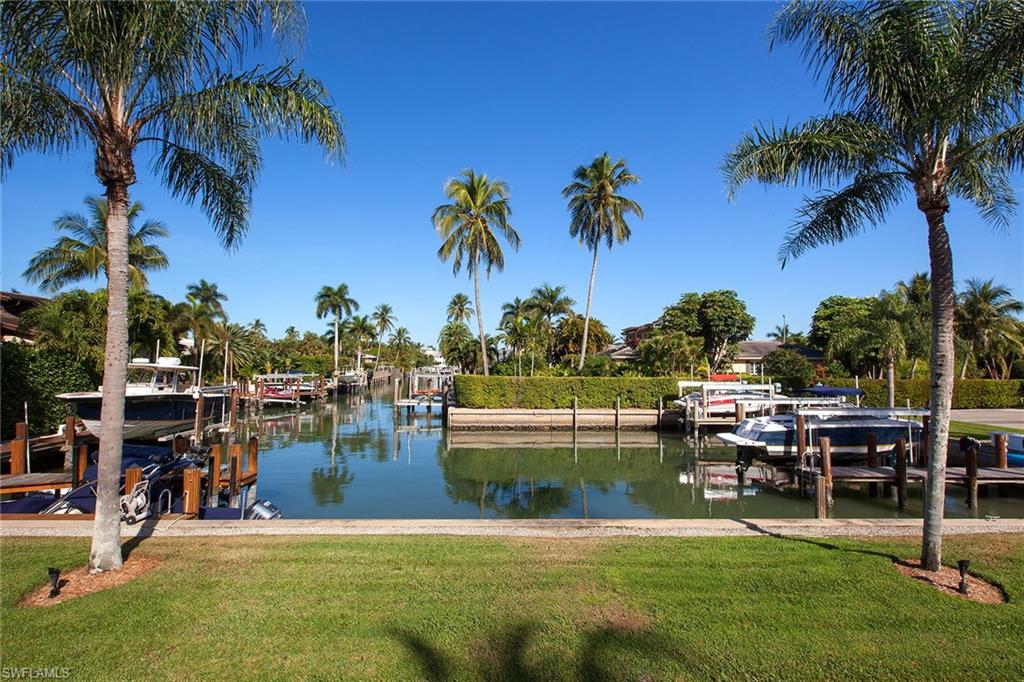 12 Sabre Lane Naples, FL 34102 - Photo 7 of 17 a view of a swimming pool with a table and chairs