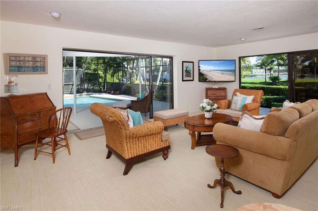 12 Sabre Lane Naples, FL 34102 - Photo 8 of 17 a living room with furniture and a floor to ceiling window