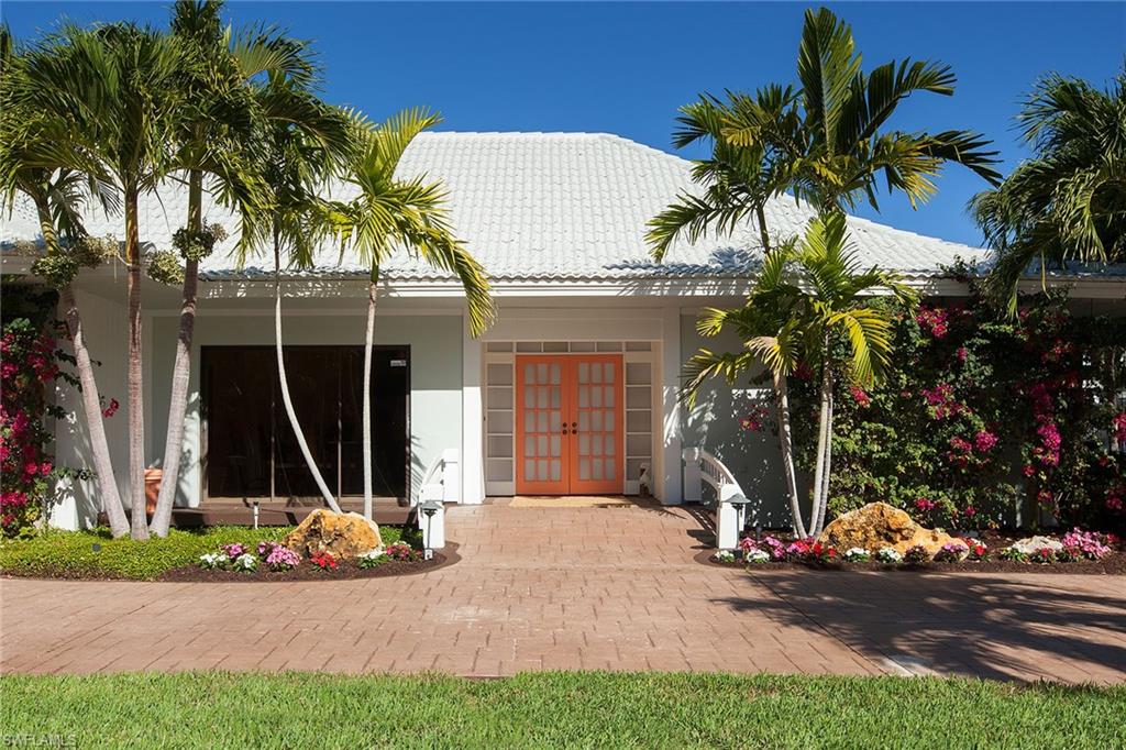 12 Sabre Lane Naples, FL 34102 - Photo 10 of 17 a view front of house with a yard and palm trees