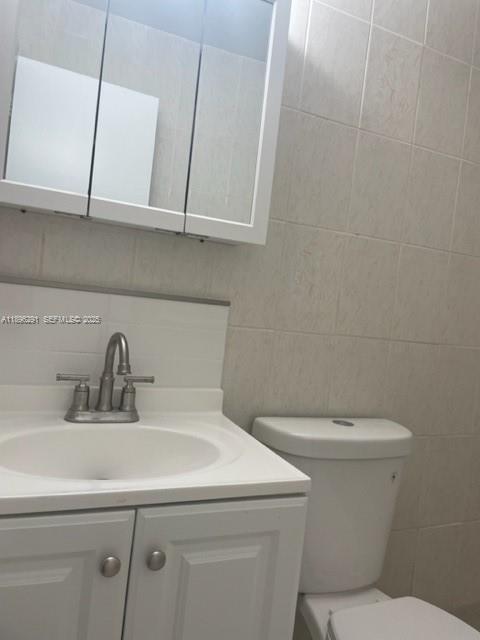 6141 Wiley Street Hollywood, FL 33023 - Photo 15 of 27 a bathroom with a toilet sink and mirror