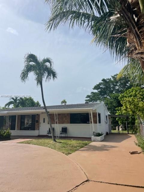 6141 Wiley Street Hollywood, FL 33023 - Photo 17 of 27 a front view of a house with garden and parking