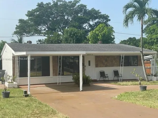 a view of a house with a backyard and a tree