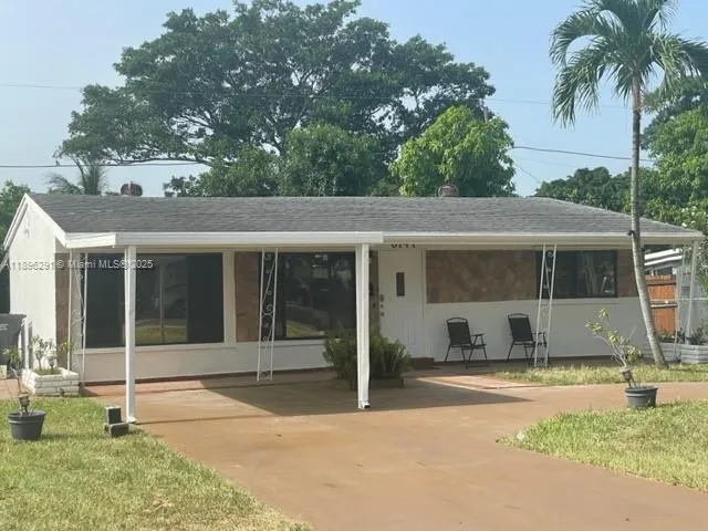 a view of a house with a backyard and a tree