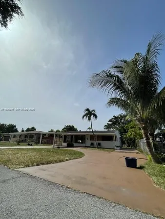 a view of a house with backyard and trees