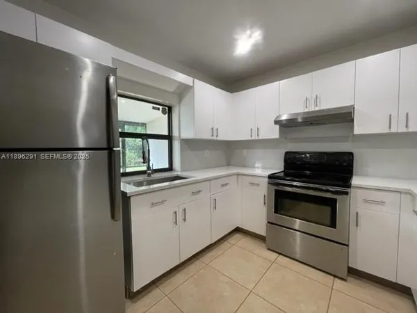 a kitchen with granite countertop white cabinets white stainless steel appliances and sink