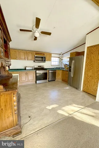 a living room with stainless steel appliances kitchen island granite countertop furniture and a kitchen view
