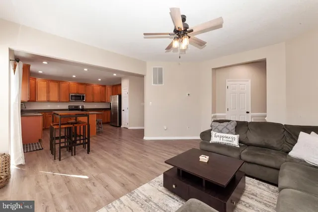 a living room with furniture and a dining table with kitchen view