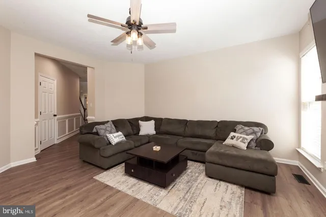 a living room with furniture and wooden floor